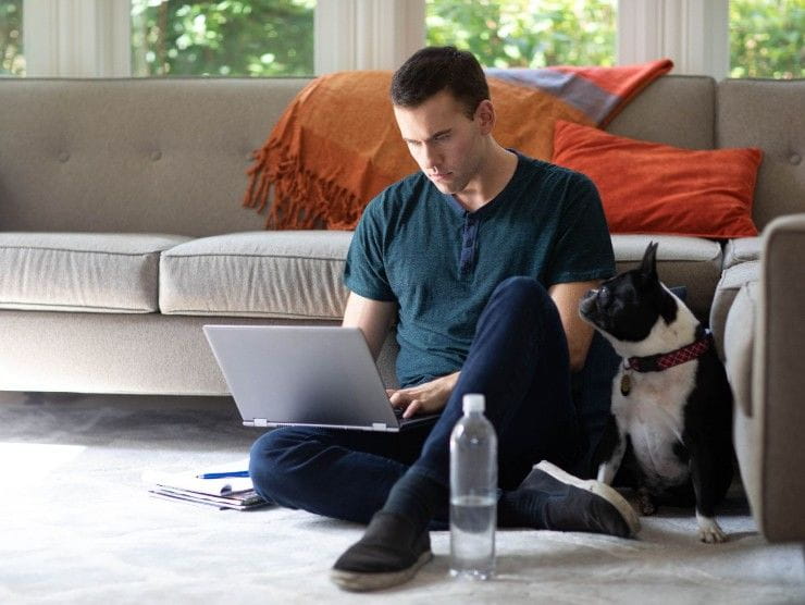 adult learner sitting with laptop and dog 