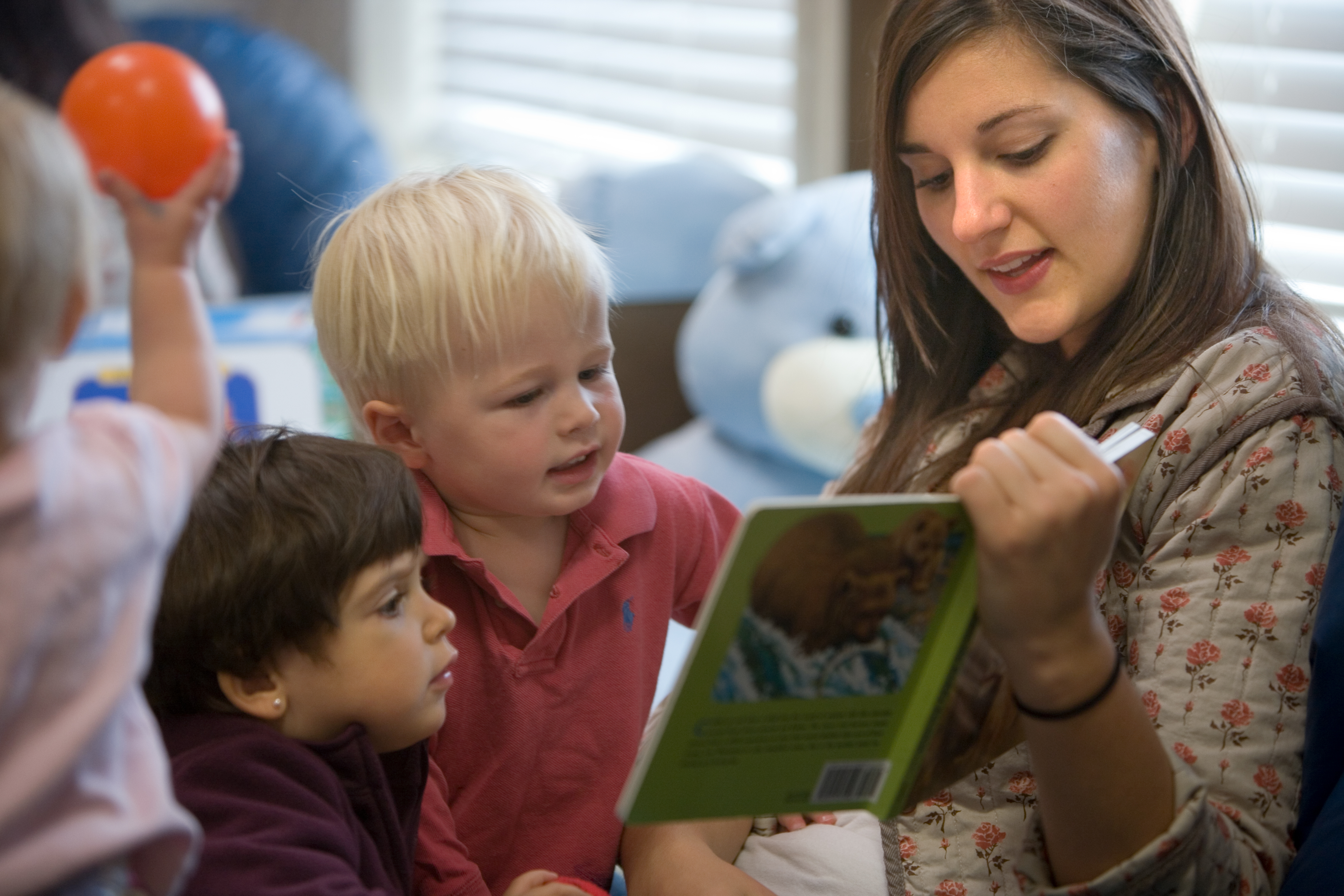 Teacher reading to two toddlers