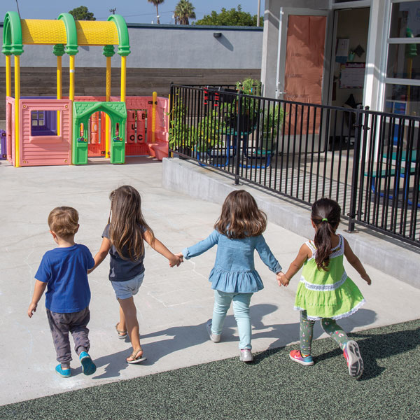 Academy Preschool class holding hands on the playground