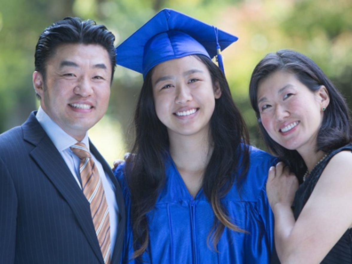 smiling graduate with their parents
