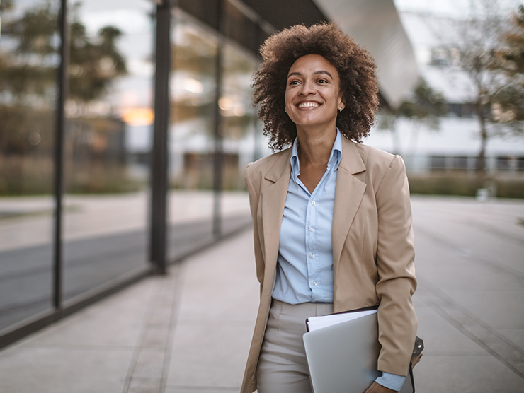 female professional of color smiling outside of office