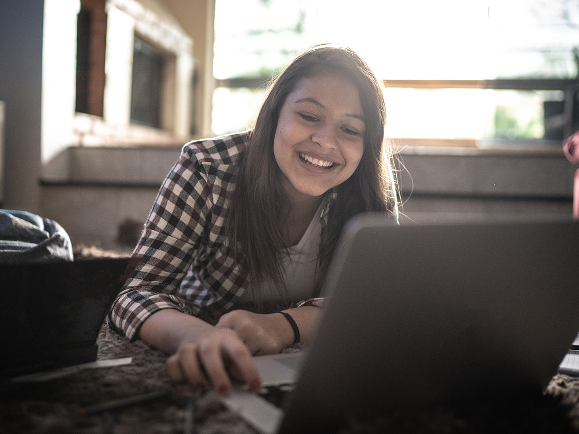 Girl on her computer smiling
