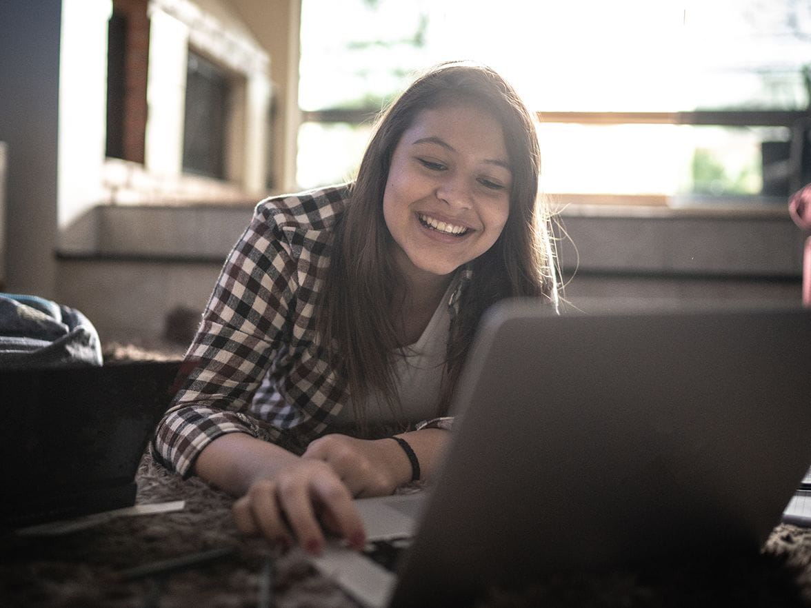 Girl on her computer smiling