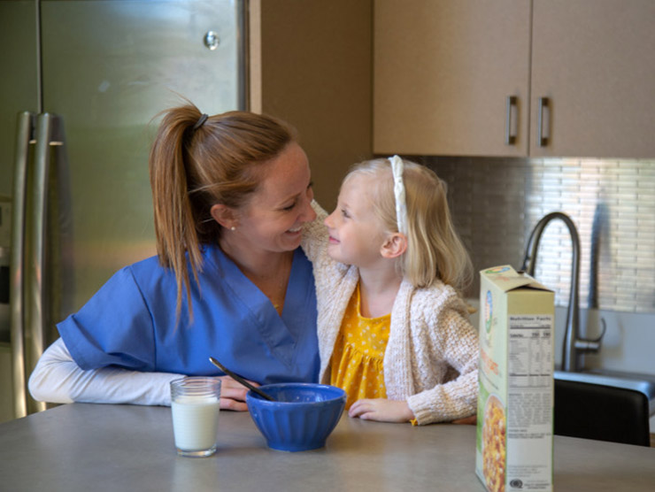 Nurse and working mom eating breakfast with her daughter