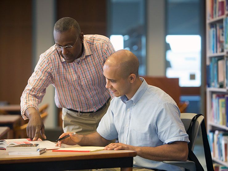 Young man and mentor studying using tuition assistance form his employer
