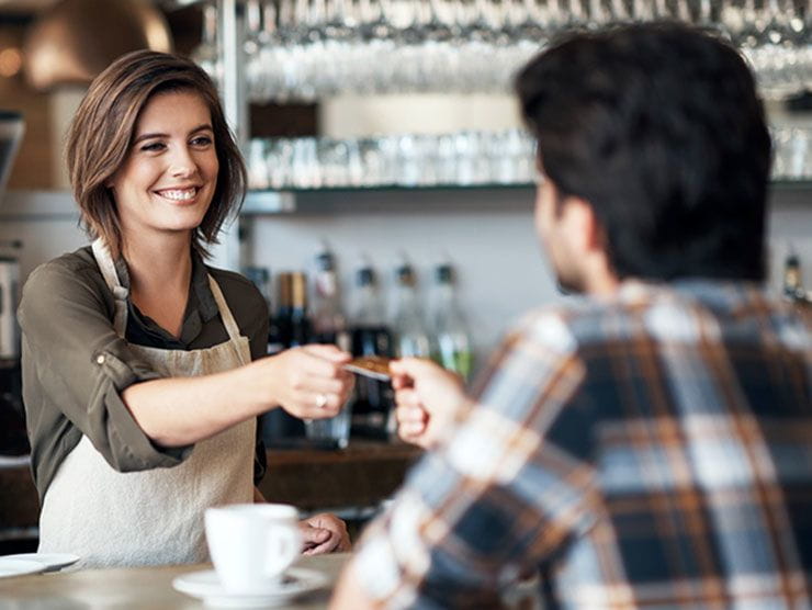  Female barista handing a customer his credit card back
