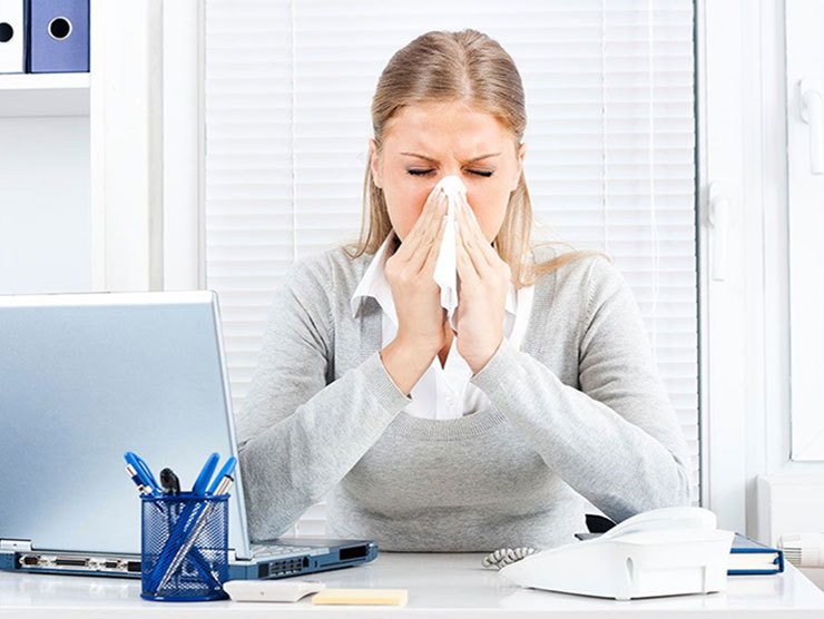 Woman sick with the flu still trying to work