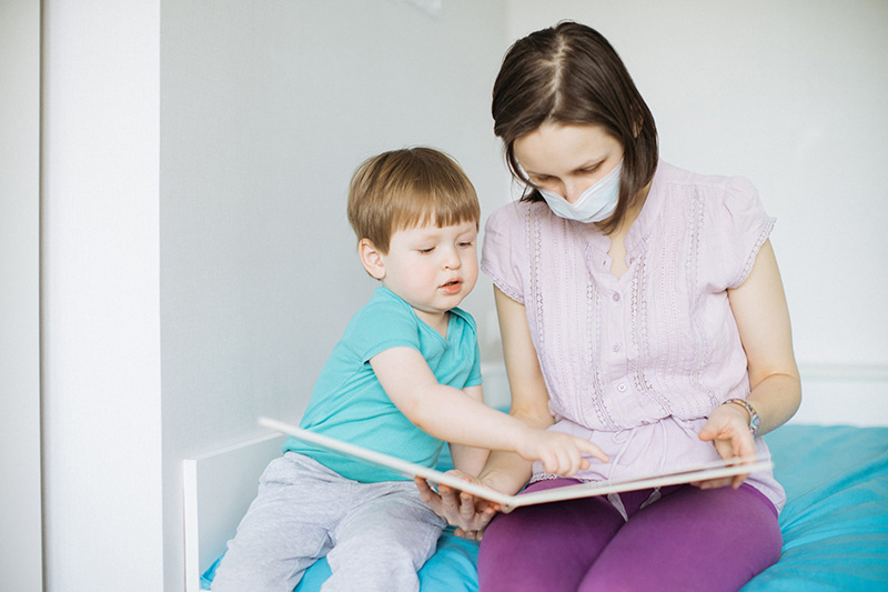In-home caregiver reading with a toddler