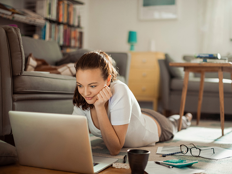 Young female professional working from home in pajamas