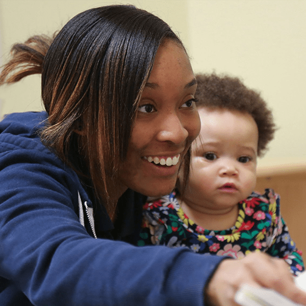 Early education teacher cares for infant at daycare