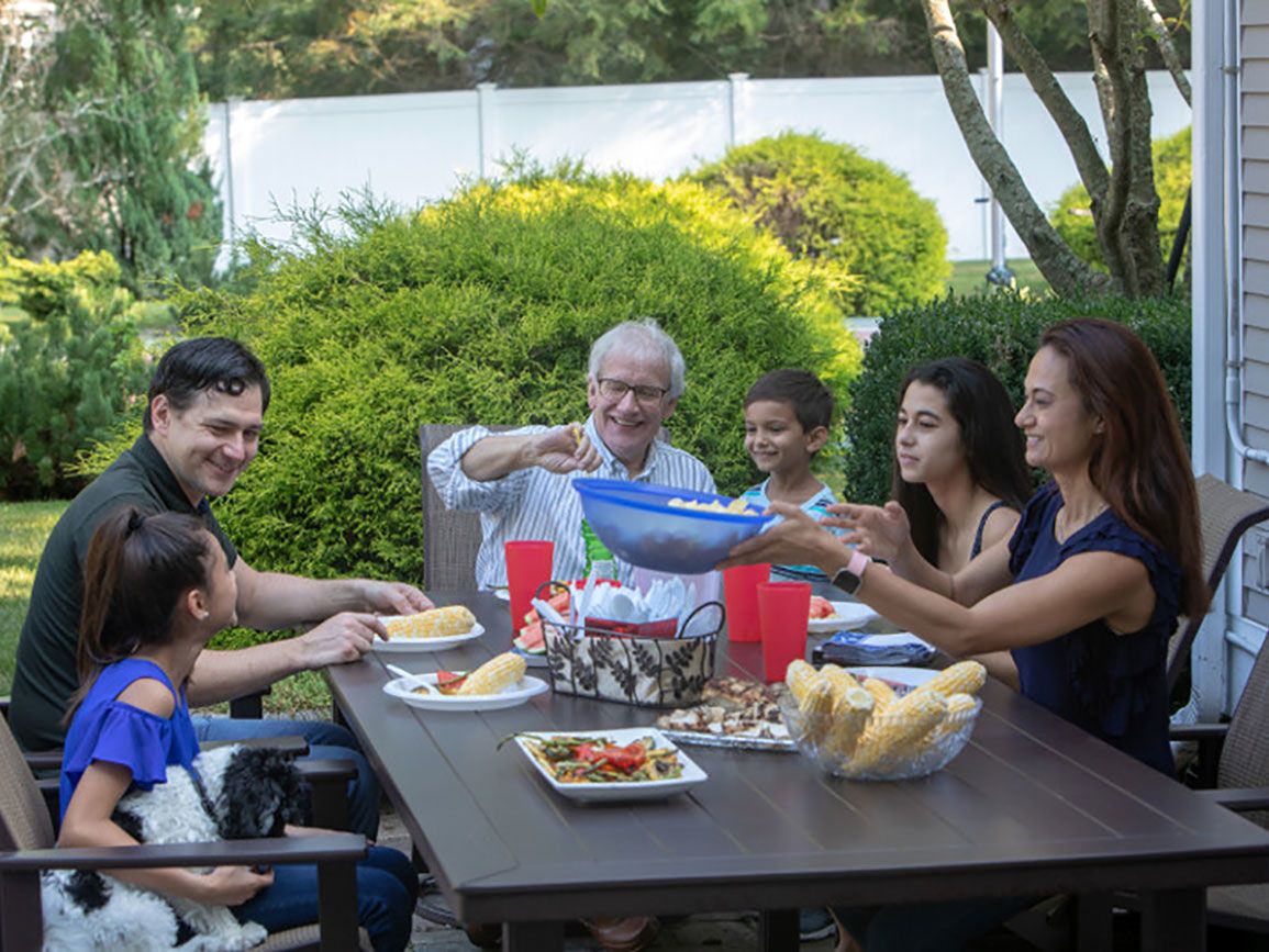 Multiple family generations having dinner together outside