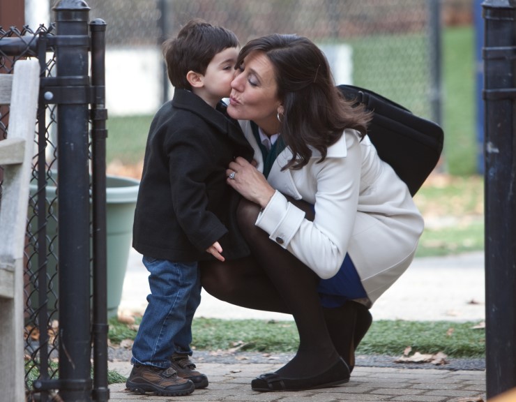 A working mother hugs her son goodbye before dropping at daycare