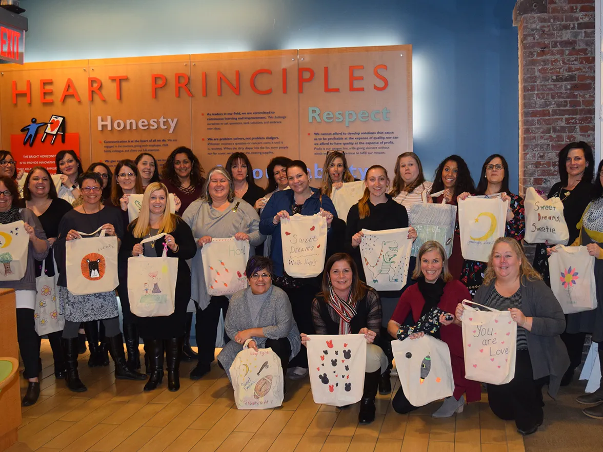 Bright Horizons employees in front of HEART principles sign