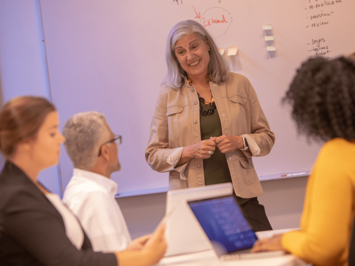 Smiling employee conducting meeting in meeting room