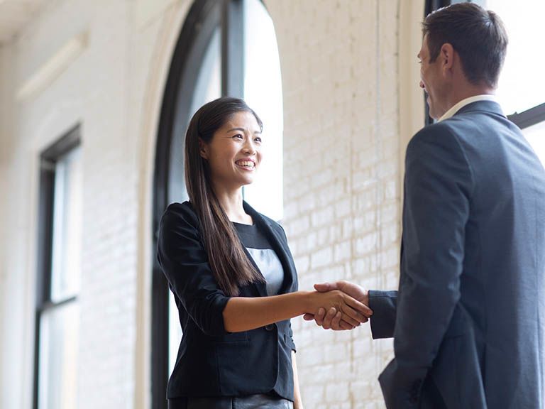 Professional woman and man shaking hands