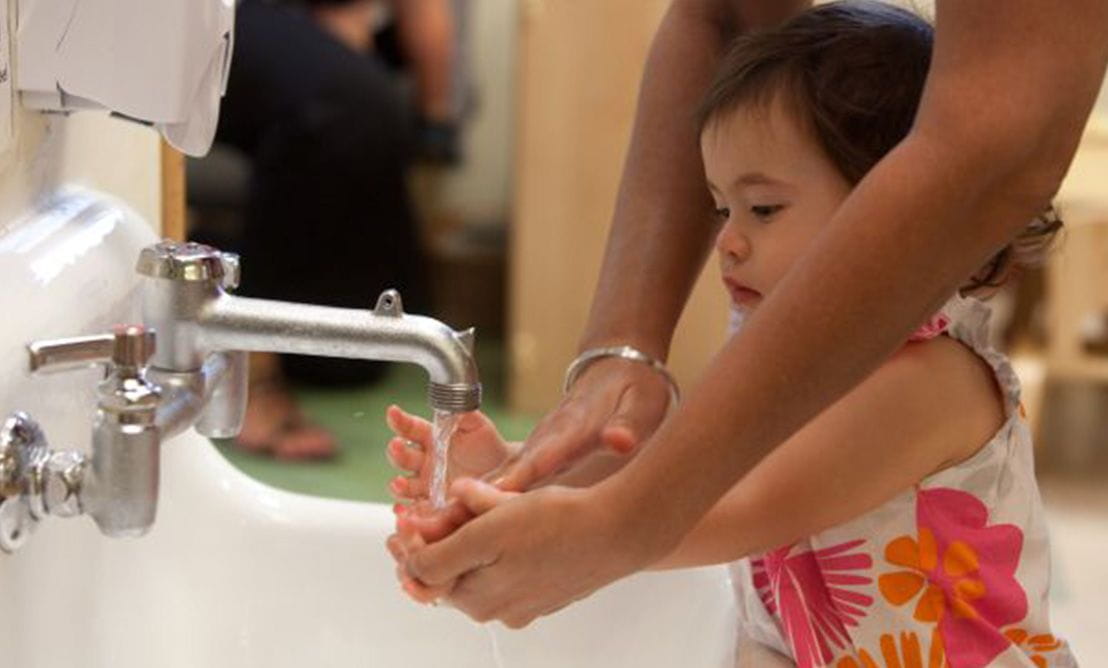 toddler girl learning to wash hands at Bright Horizons