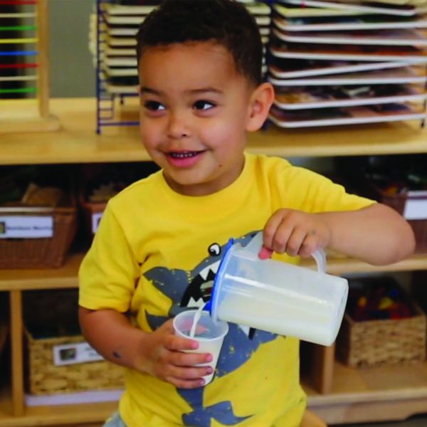 Preschool boy pouring water