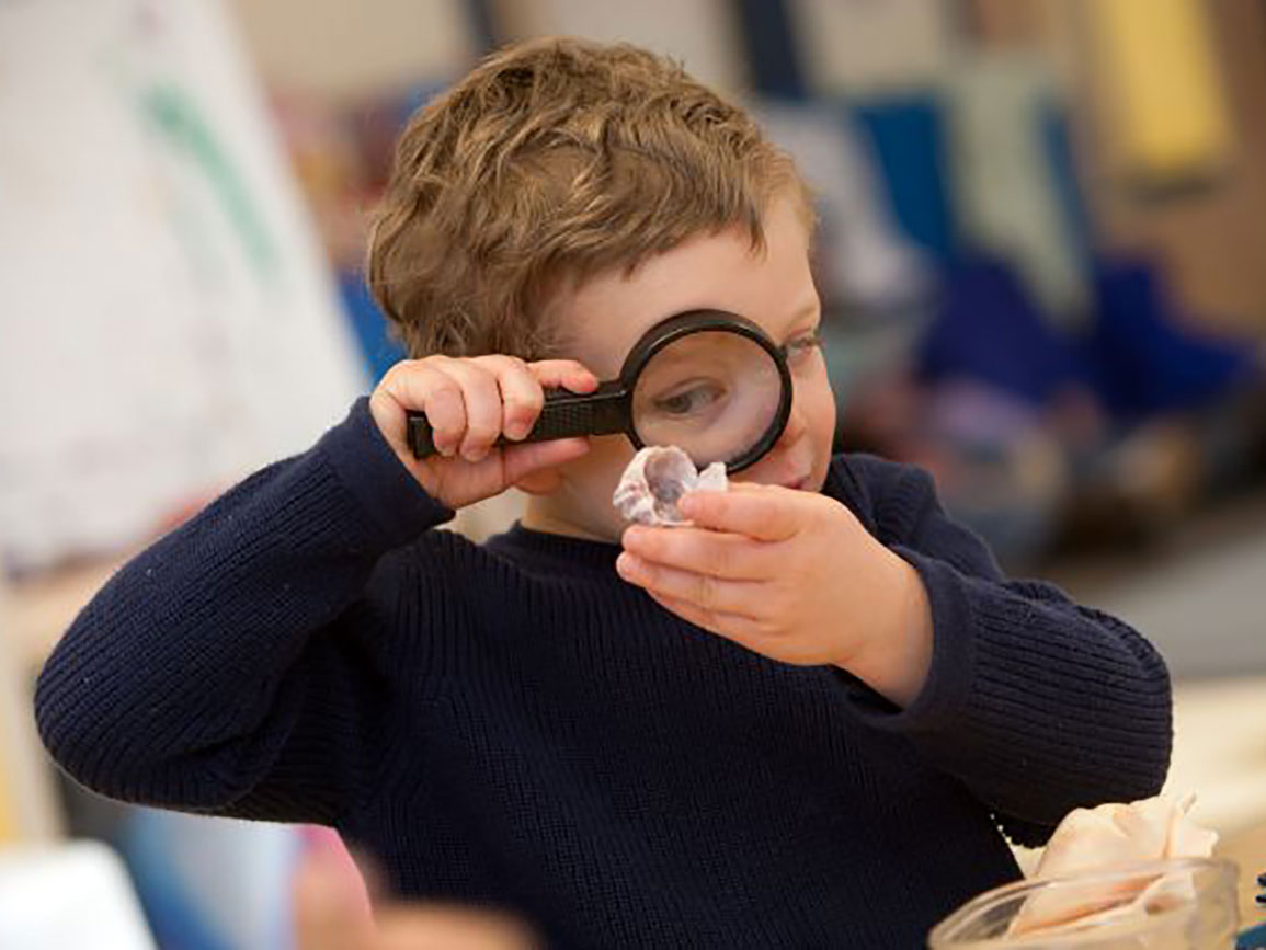Preschool boy with magnifying glass