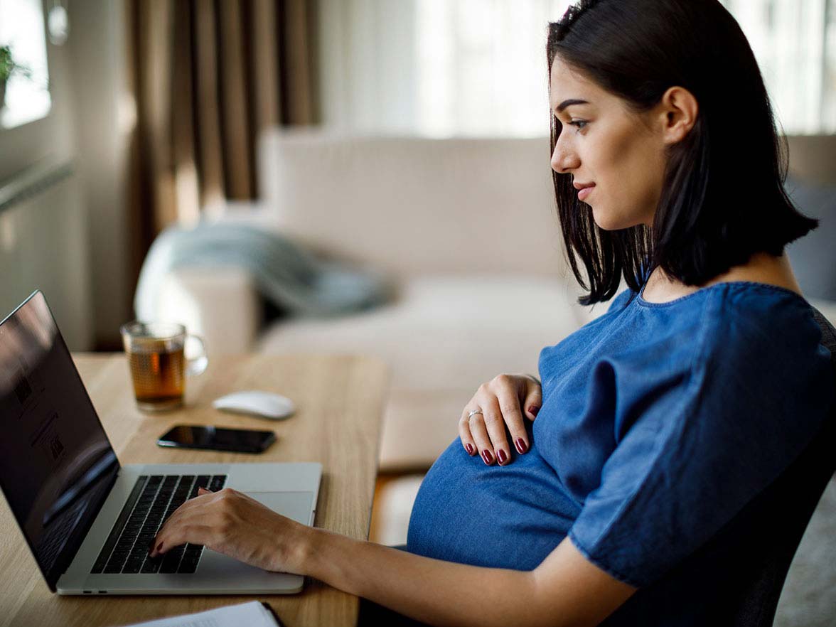Bright Horizons Modern Family Index Pregnant Woman Working At Desk