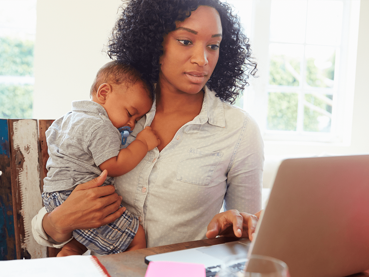 mother working from home holding baby