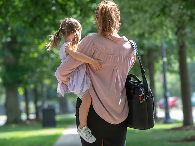 Working mom carrying daughter