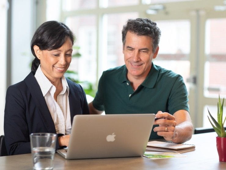 co-workers sitting at table with laptop 