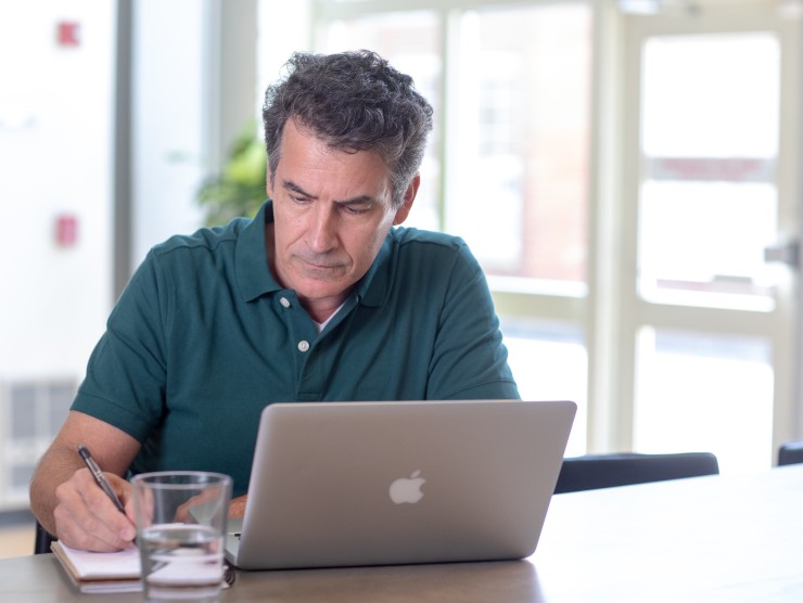 man sitting at table with laptop 