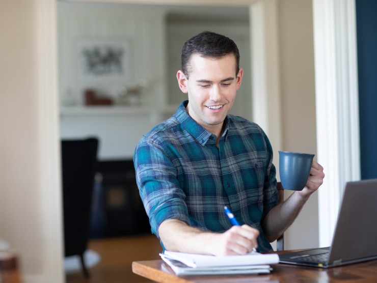 man sitting at counter with laptop 