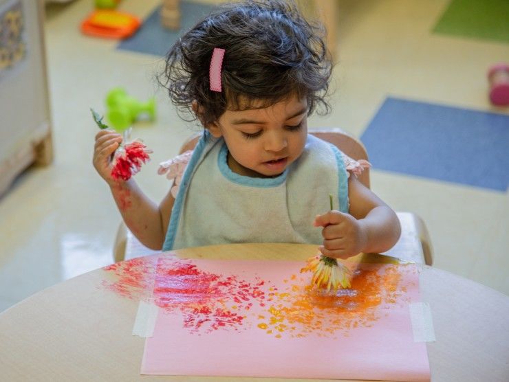 child finger painting at table 