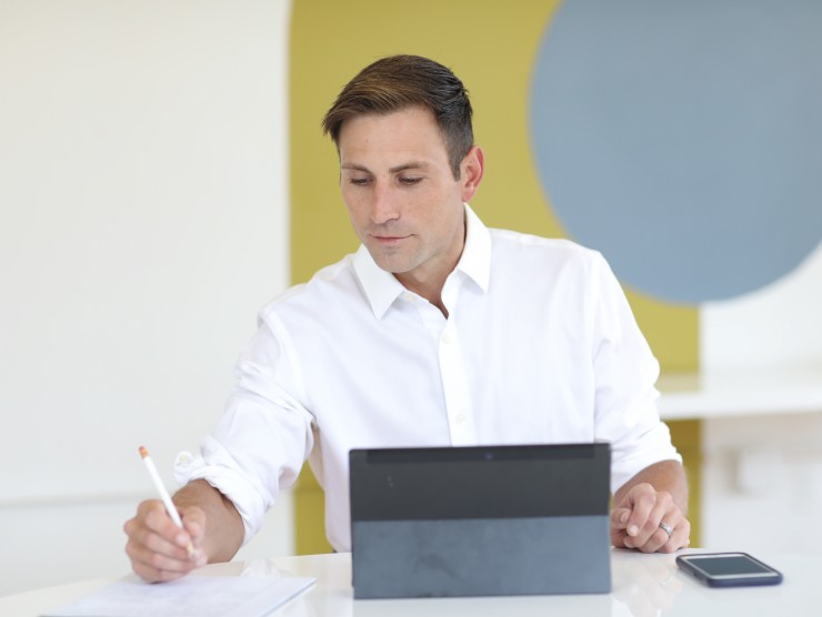 man sitting at table with laptop