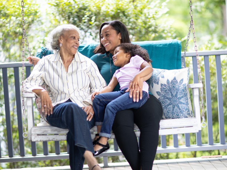 grandmother, mom and child sitting on porch 