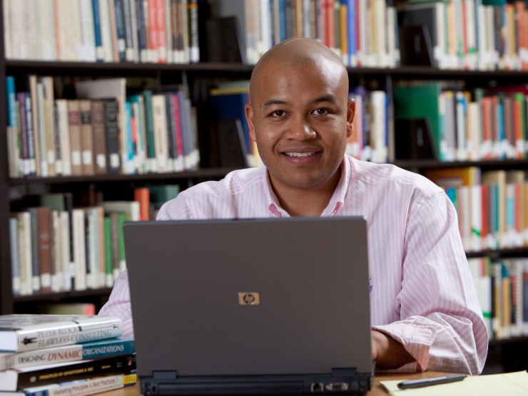 man sitting in library with laptop