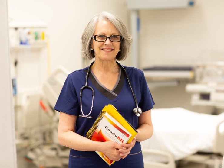 nurse standing with books 