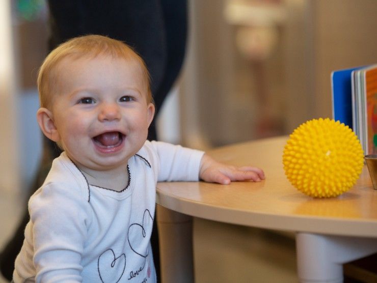 toddler standing and smiling 