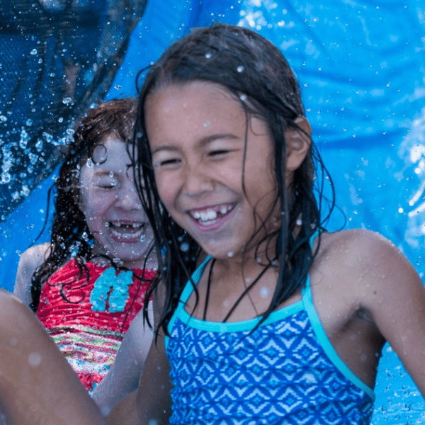 two girls playing on water slide