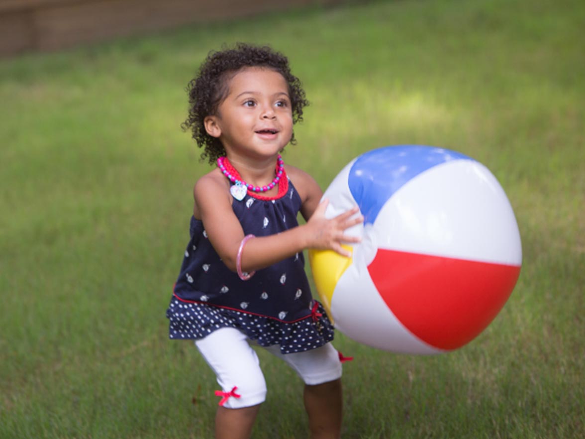 Preschool girl outside with beachball