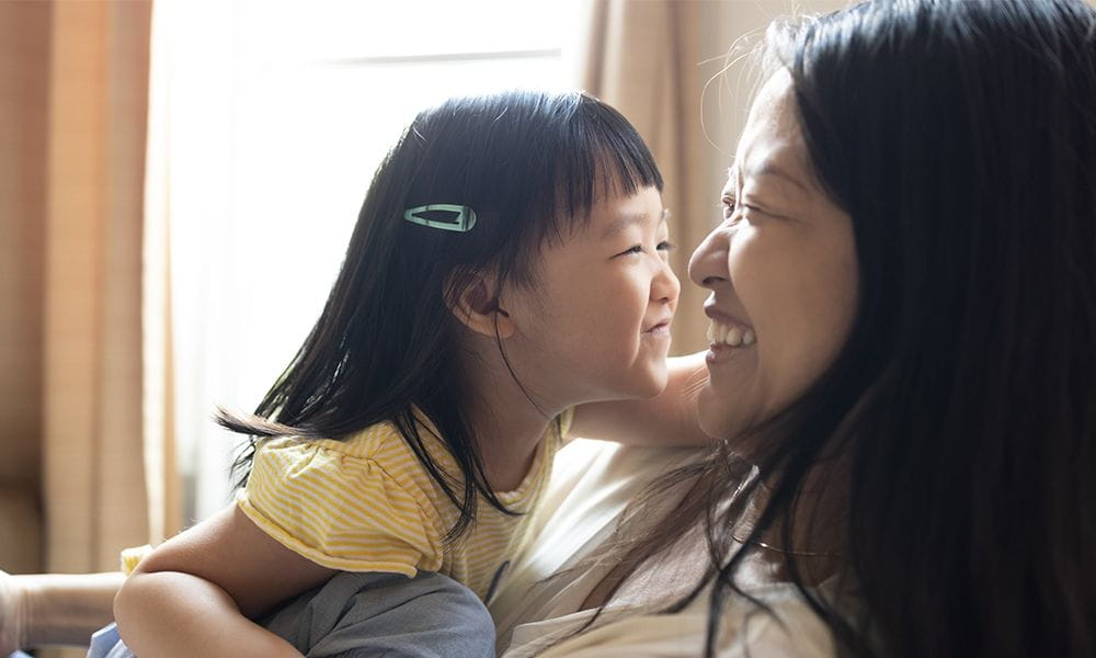 Mother and daughter smiling face to face