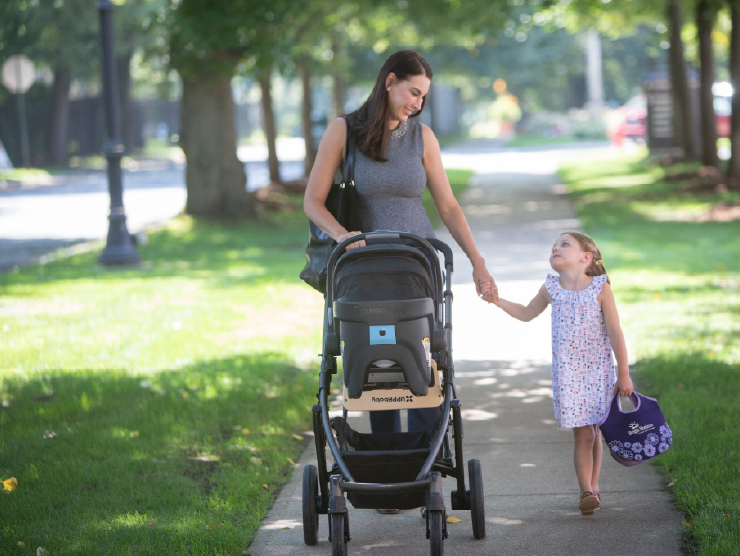 Woman walking with stroller and child