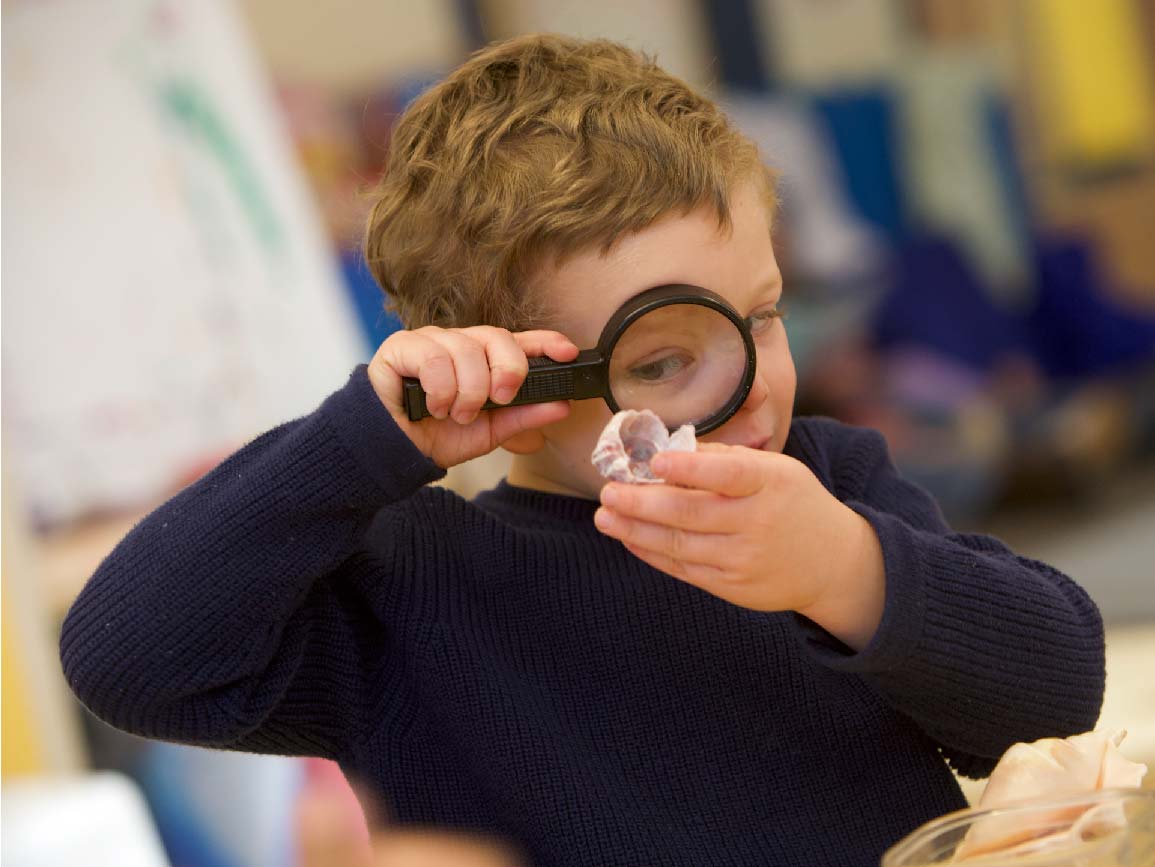 Child using a magnifying glass