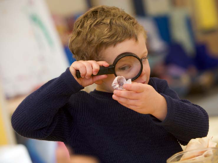 Child playing with magnifying glass