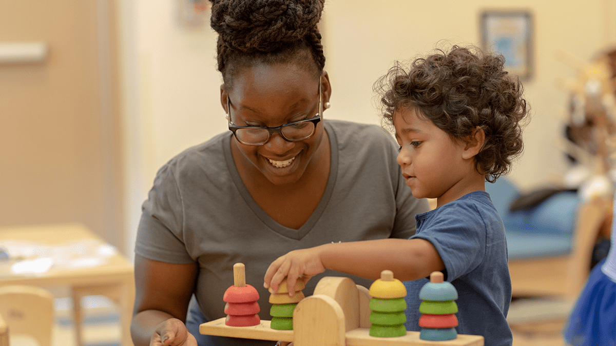 Bright Horizons daycare teacher teaches sensory skills to toddler in an educationally rich child care center
