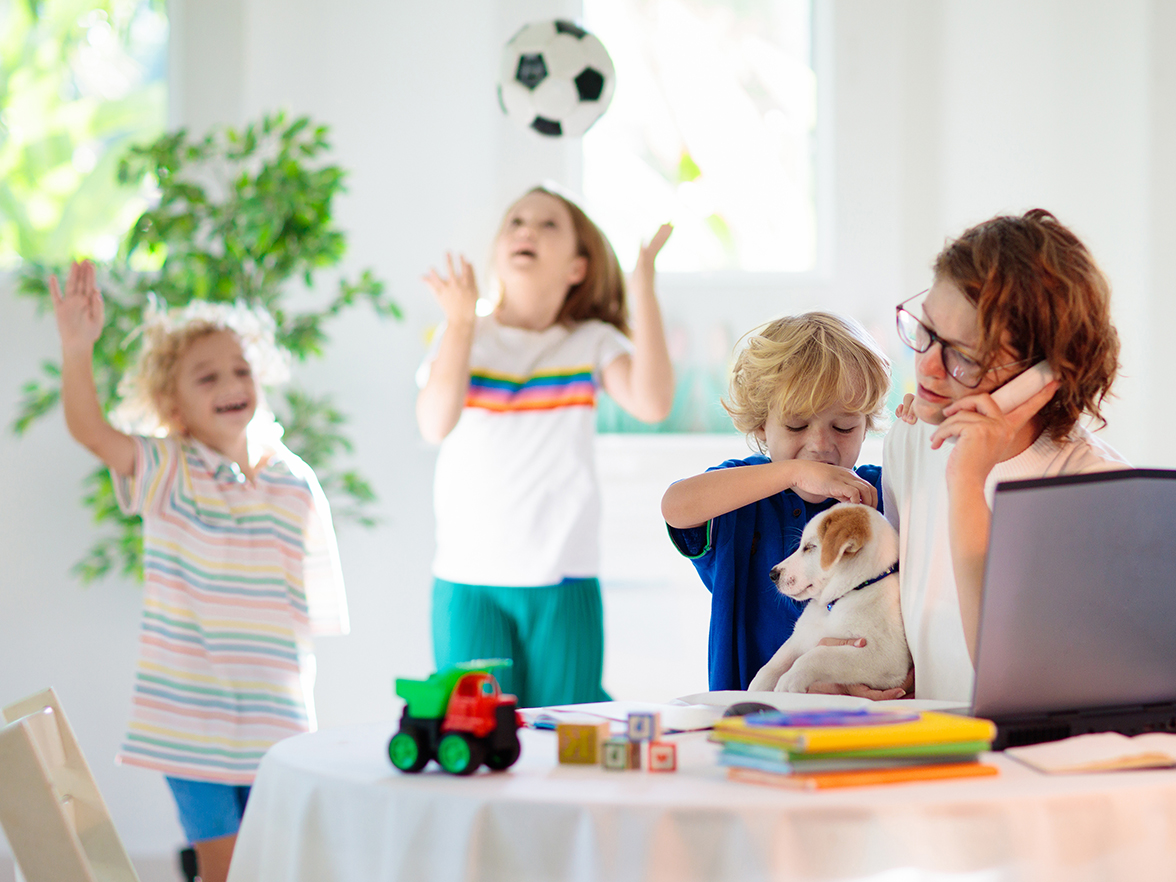 busy mother with children playing games next to her