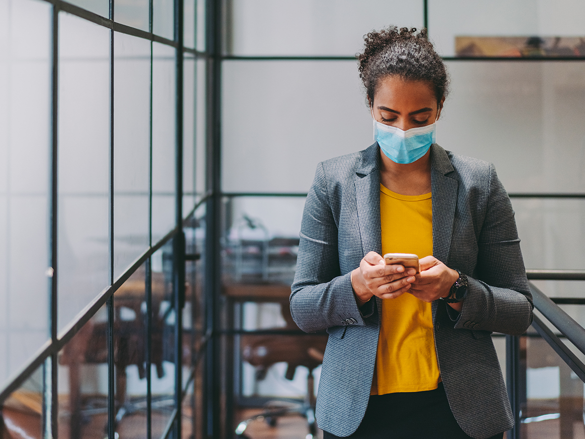 female in office texting on phone