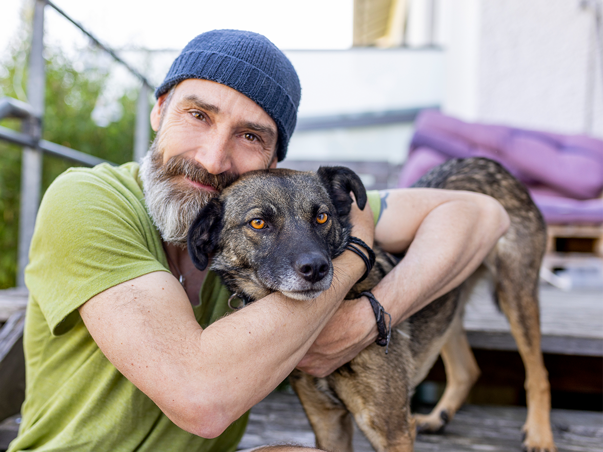 Man hugging a dog smiling