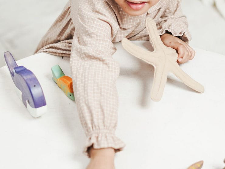 Toddler playing with wooden animals at day care 