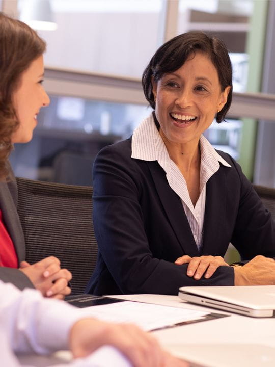 A group of business women leading a meeting together.