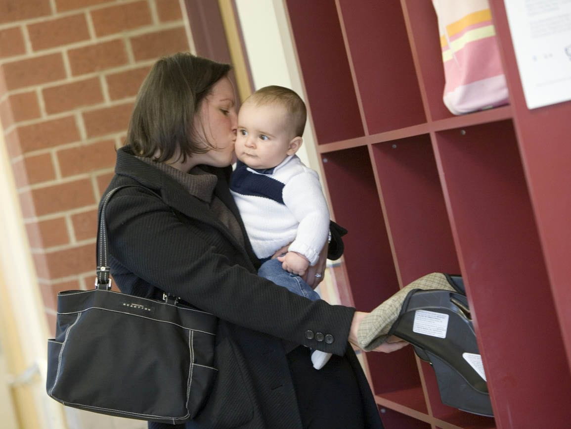 A mother dropping off her infant at child care