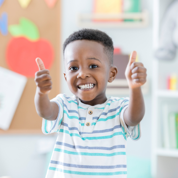 smiling child with thumbs up