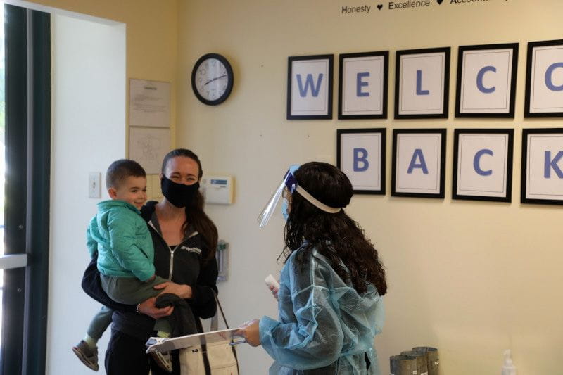 Working mom dropping her son off at child care during COVID