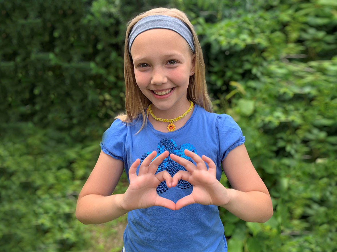 girl making heart symbol with hands